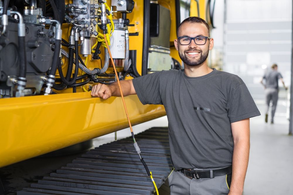 MAATS technician performing inspection on hydraulic system of construction equipment.