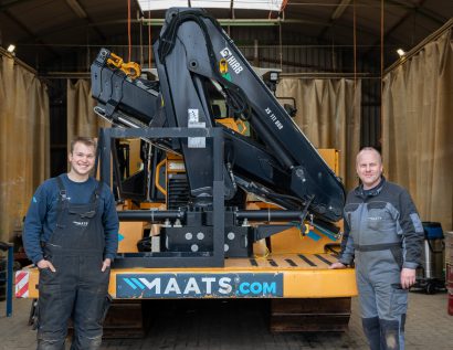 MAATS technicians standing beside hydraulic equipment inside workshop.